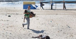 A boy on a Gaza beach killed in an Israeli attack is carried away.